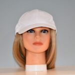 medium length blonde synthetic wig attached to hat on mannequin head